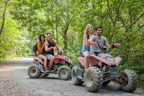 young couple or friend happy while riding an ATV