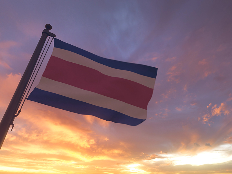 Costa Rica-flag on flagpole by evening sunset sky